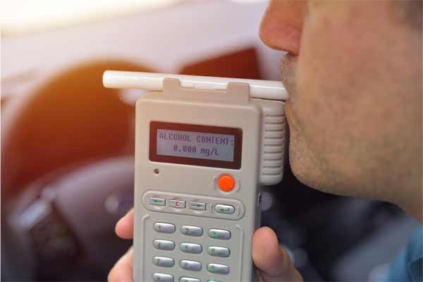 Man blowing the breathalizer - Blood Alcohol Content Laws